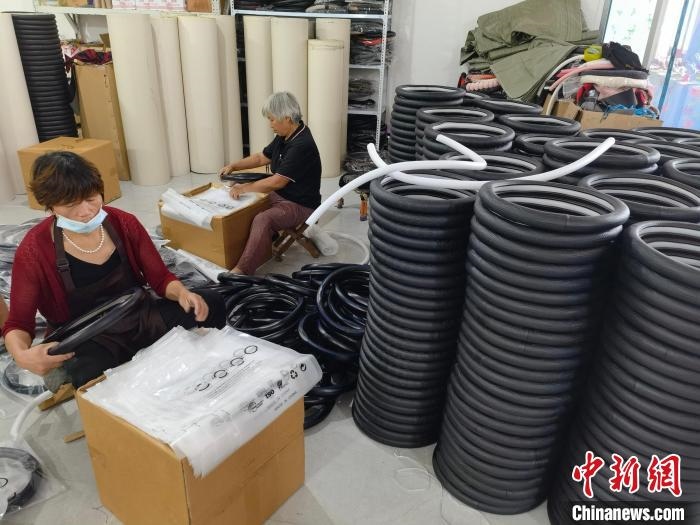 圖為村民在汽車飾品企業(yè)生產(chǎn)車間中工作?！巫雍?攝