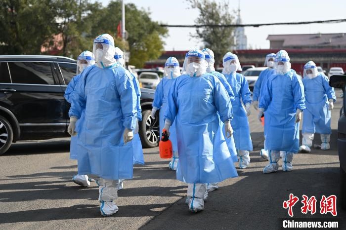 圖為醫(yī)務(wù)人員在封閉小區(qū)做防控工作?！⑽娜A 攝