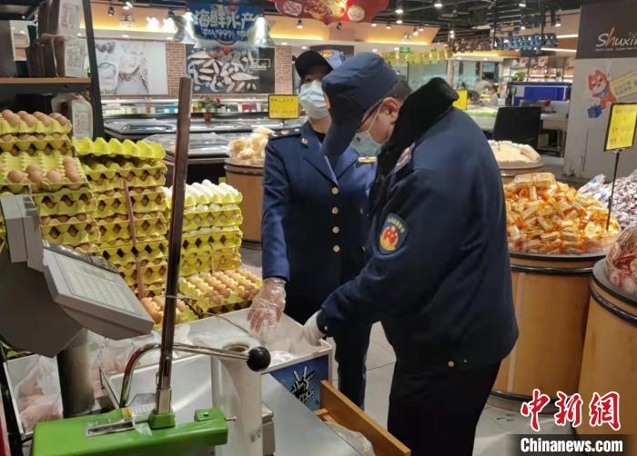 圖為疫情期間，甘肅嘉峪關(guān)市場監(jiān)管局工作人員檢查蔬菜市場?！?柴佳楠 　攝