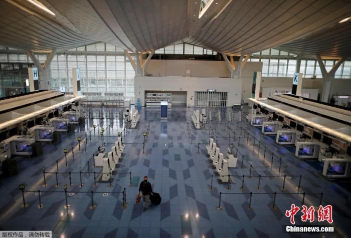 資料圖：日本東京，東京國際機(jī)場(chǎng)，一名乘客在國際航班航站樓的登機(jī)區(qū)。
