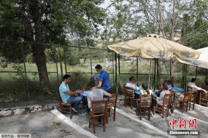 資料圖：希臘雅典，人們在一家露天咖啡享用飲品。