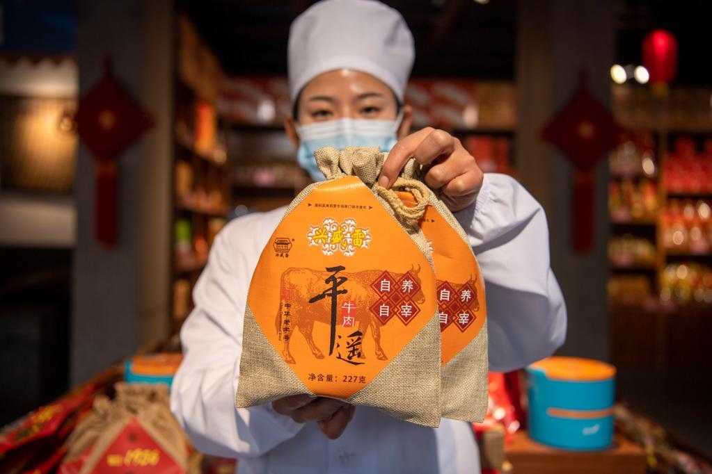 1月27日，在平遙古城南大街的一家平遙牛肉店內(nèi)，工作人員展示一款牛肉產(chǎn)品。新華社記者 楊晨光 攝