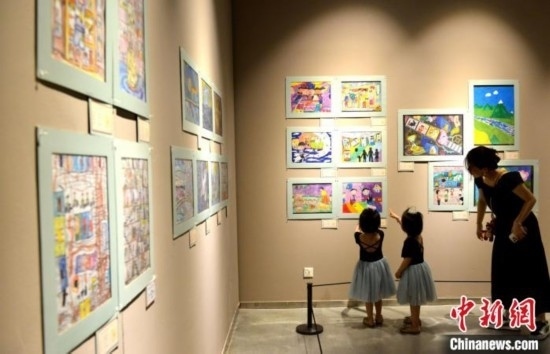 圖為家長(zhǎng)帶著孩子參觀展覽。呂明 攝