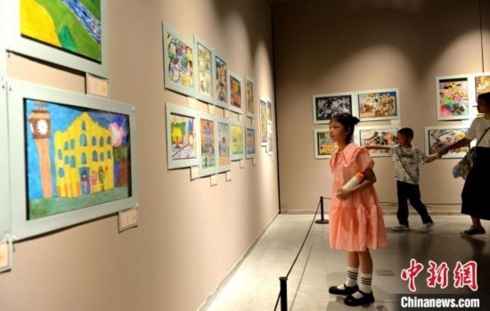 圖為家長(zhǎng)帶著孩子參觀展覽。呂明 攝