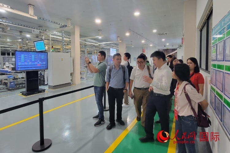 廣汽埃安工作人員向外媒記者進(jìn)行介紹。人民網(wǎng) 寧玉瑛攝