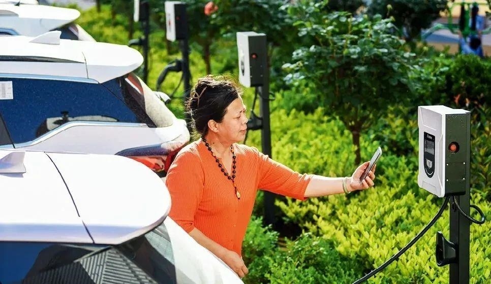 2023年5月24日，山東省膠州市新立街小區(qū)內(nèi)一位居民使用電動汽車充電樁掃碼充電。該小區(qū)加裝各類智慧設(shè)備，打造“智慧社區(qū)”，為居民生活帶來便利。