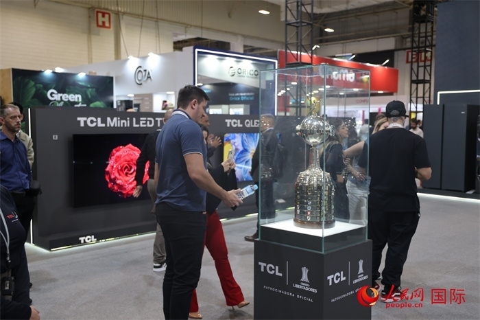 參觀者在TCL展臺前觀看南美解放者杯獎杯，據(jù)介紹，TCL是南美解放者杯（2023—2026賽季）全球官方合作伙伴。（人民網(wǎng)記者 時元皓攝）