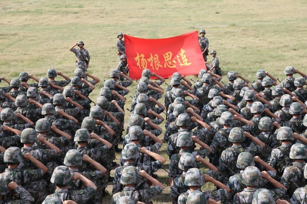 ↑“楊根思連”官兵執(zhí)行任務(wù)前向連旗宣誓（資料照片）。新華社發(fā)