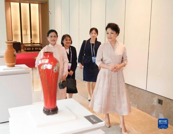7月27日下午，國(guó)家主席習(xí)近平夫人彭麗媛在四川成都會(huì)見陪同印度尼西亞總統(tǒng)佐科來華出席第31屆世界大學(xué)生夏季運(yùn)動(dòng)會(huì)開幕式并訪華的總統(tǒng)夫人伊莉亞娜。這是彭麗媛和伊莉亞娜欣賞成都特色非遺工藝品。新華社記者 丁林 攝