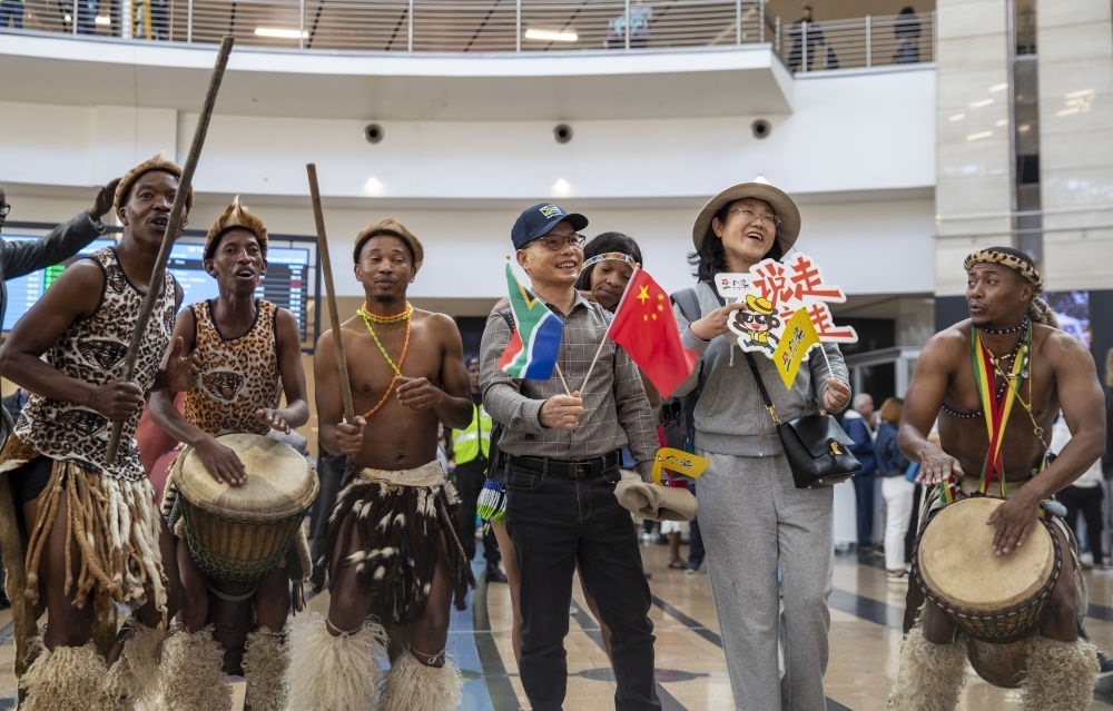 在南非約翰內(nèi)斯堡坦博國際機場，南非舞蹈演員歡迎中國試點恢復(fù)出境團隊旅游后首批抵達南非的中國游客（2023年3月29日攝）。