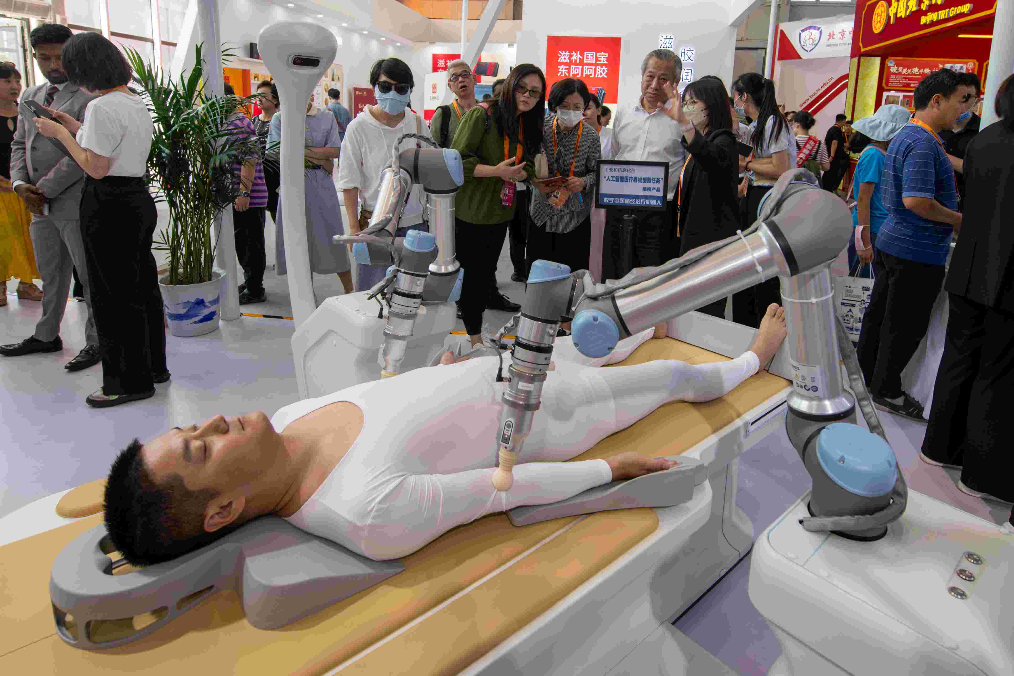 在位于首鋼園的健康衛(wèi)生服務(wù)展區(qū)，觀眾正在參觀數(shù)字中醫(yī)循經(jīng)治療機(jī)器人。人民網(wǎng)記者 翁奇羽攝