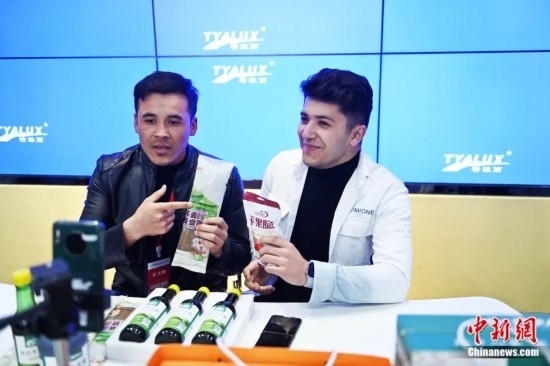 2023年3月，甘肅省慶陽(yáng)市環(huán)縣電商創(chuàng)業(yè)孵化基地內(nèi)，來(lái)自蘭州文理學(xué)院的塔吉克斯坦留學(xué)生正在協(xié)助主播直播帶貨當(dāng)?shù)剞r(nóng)特產(chǎn)品。李亞龍 攝