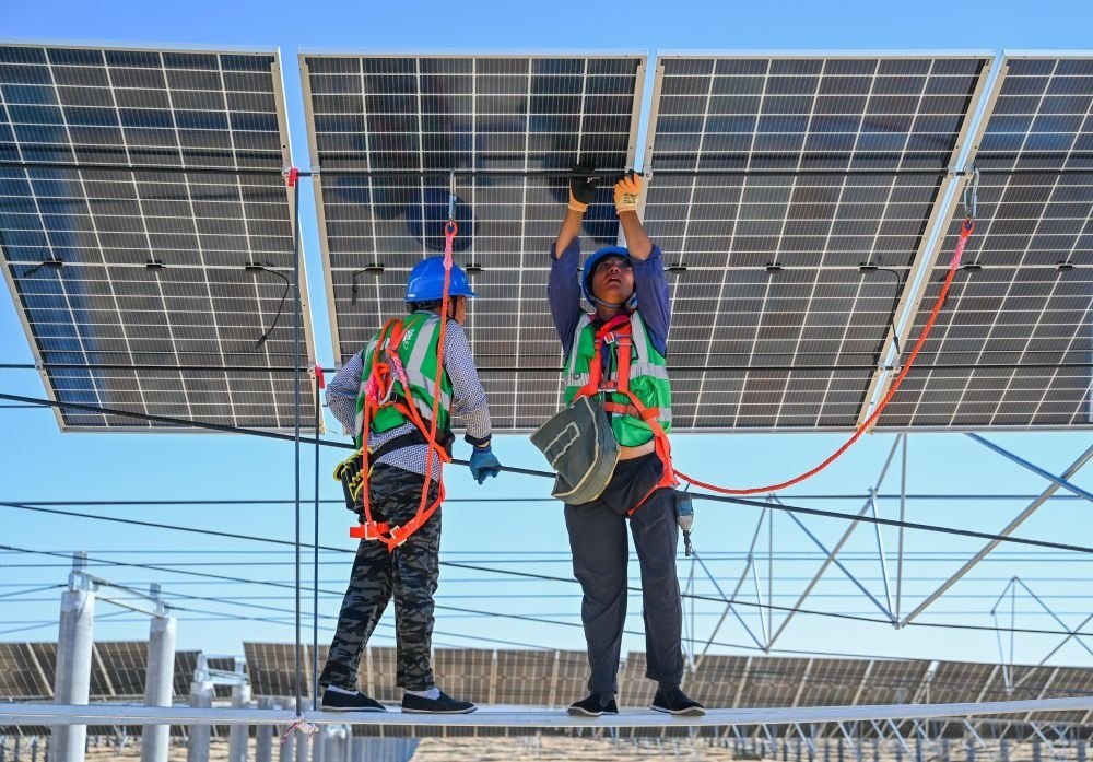 2023年7月22日，工人在位于內蒙古杭錦旗庫布其沙漠億利生態(tài)示范區(qū)的蒙西基地庫布其200萬千瓦光伏治沙項目工地安裝光伏板。新華社記者 劉磊 攝