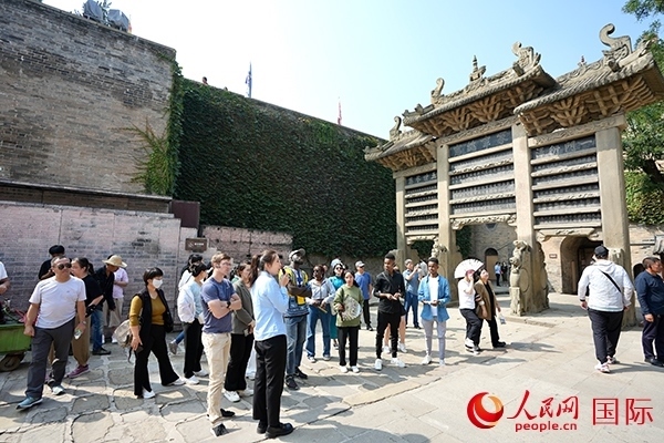 選手們認(rèn)真聆聽導(dǎo)游講解。人民網(wǎng) 盧鵬宇攝