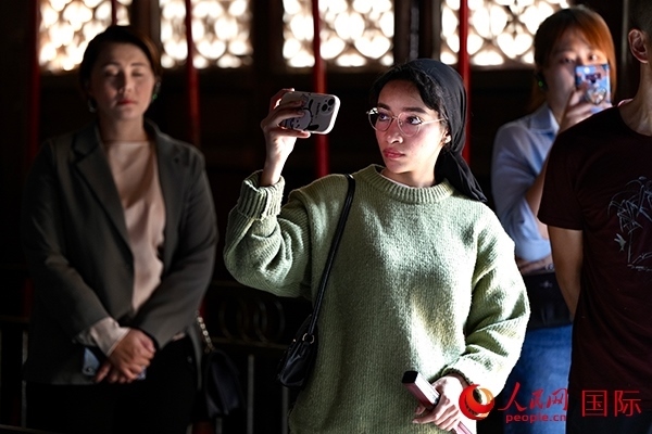 選手顏青（蘇丹）用手機記錄所見所感。人民網(wǎng) 盧鵬宇攝