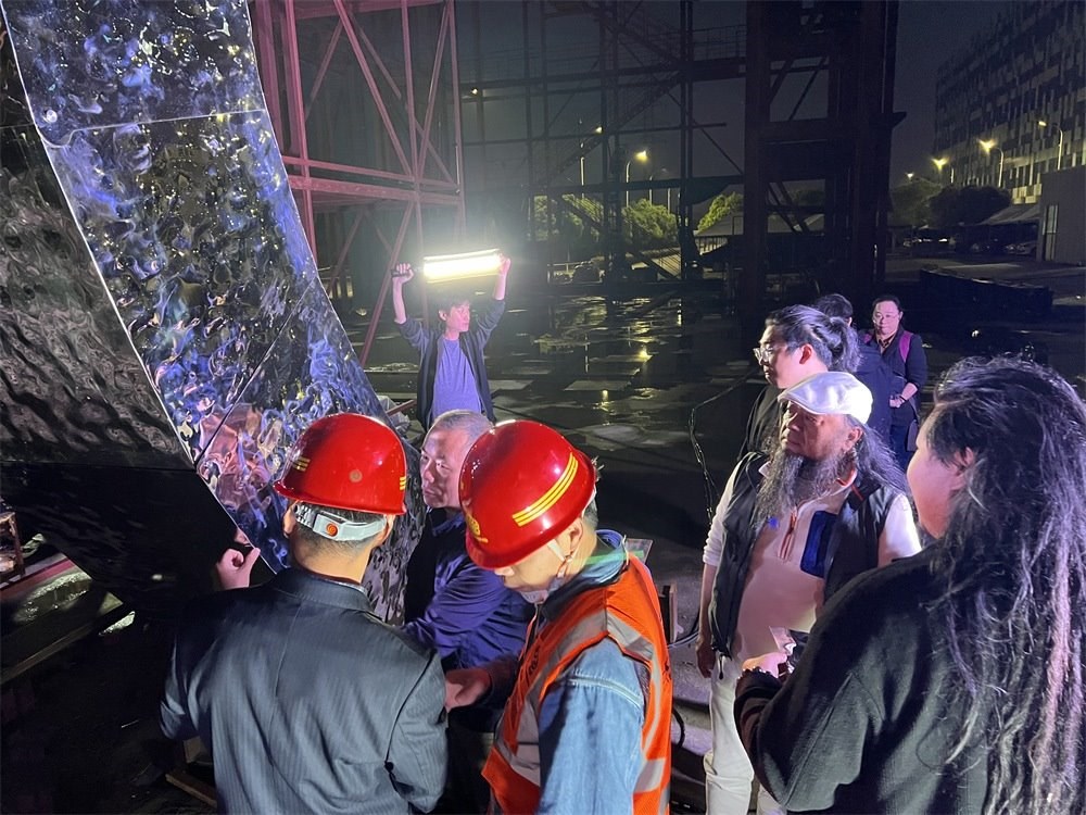 林崗（右二）和團隊查看主火炬制作進度。受訪者供圖