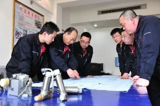 △李志強(qiáng)（左二）與班組成員在研究工作。