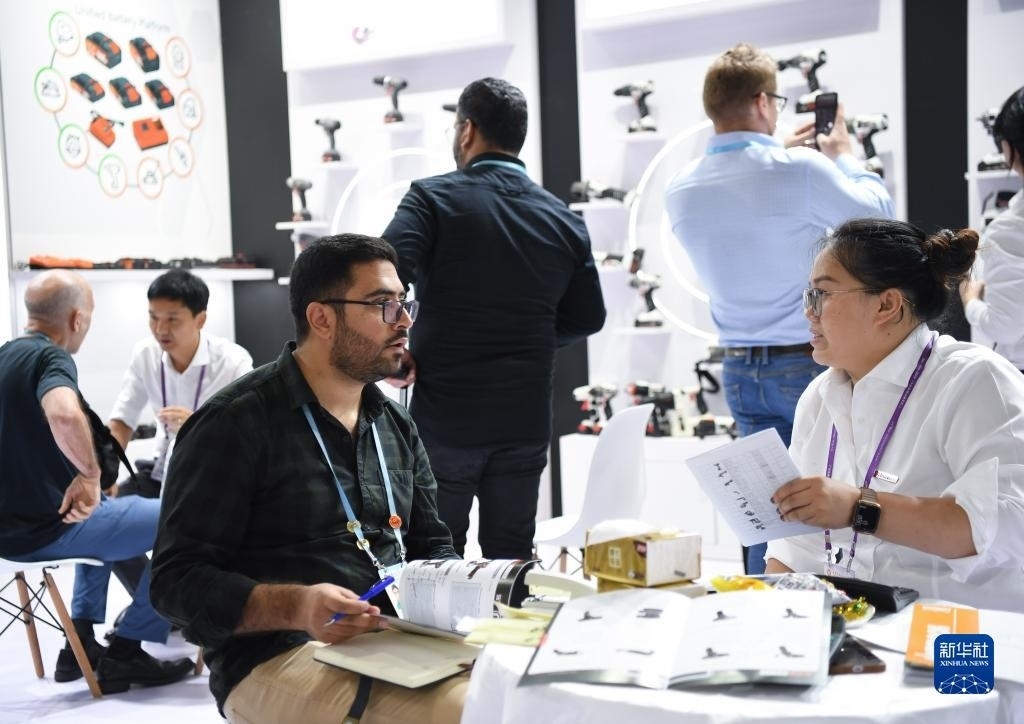 10月15日，在一家電動工具展臺，外國采購商在洽談業(yè)務。新華社記者 鄧華 攝