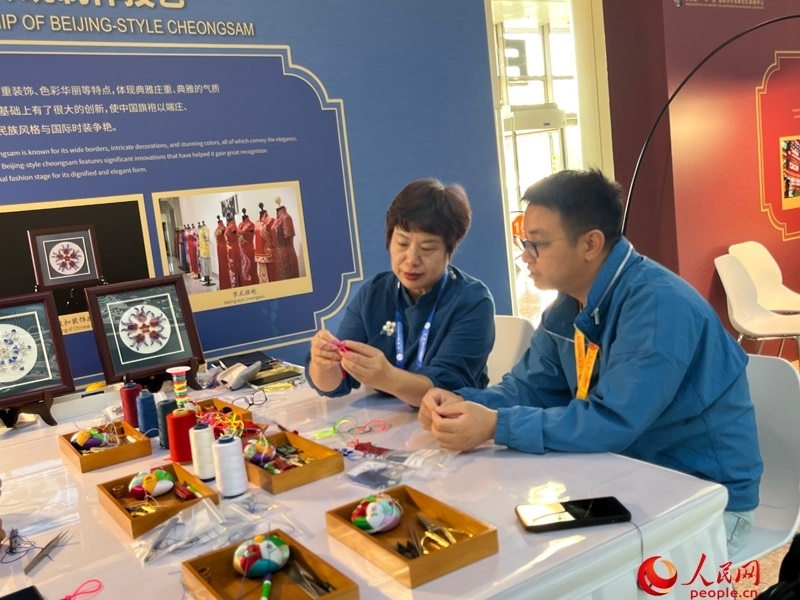 記者在新聞中心非遺傳承人展區(qū)進行體驗。人民網(wǎng)記者 杜燕飛攝