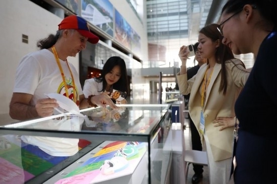 10月16日，參會(huì)記者在“一帶一路”國(guó)際合作高峰論壇新聞中心參觀展示的中國(guó)非物質(zhì)文化遺產(chǎn)展品。新華社記者 陳斌 攝