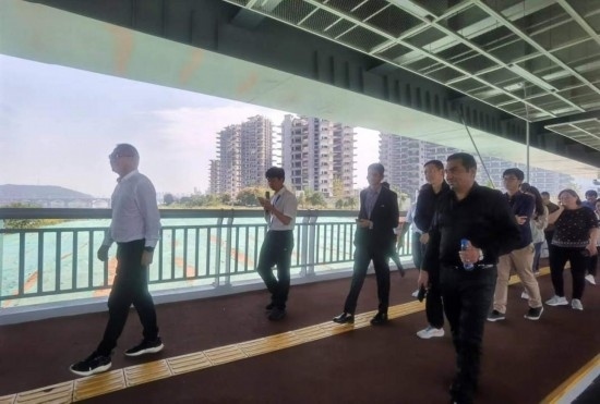 10月24日，2023“一帶一路”媒體合作論壇聯(lián)合采訪團團員走在清水塘大橋景觀通道上。本報記者 常雯宜攝