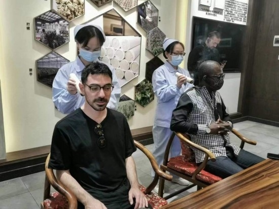 2023“一帶一路”媒體合作論壇聯(lián)合采訪團(tuán)團(tuán)員在九牛草展示館體驗艾灸。（本報記者 黃超攝）