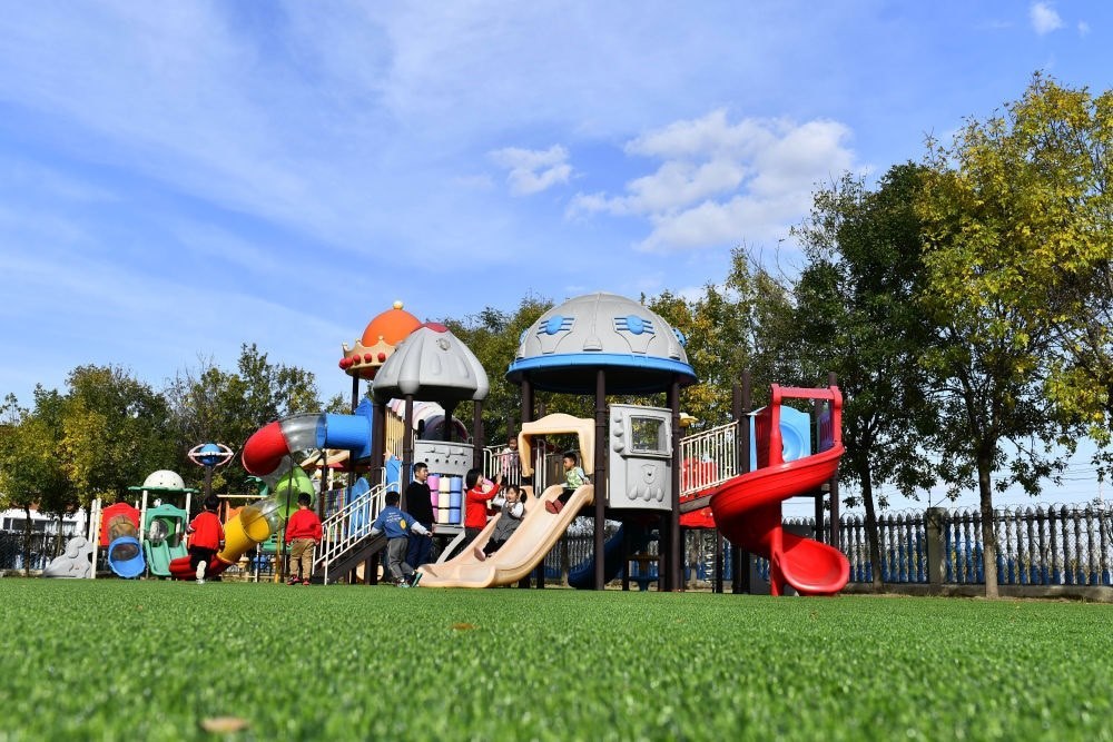 在山東省東營市墾利區(qū)楊廟社區(qū)幼兒園，孩子們在老師的帶領下進行戶外活動（2021年10月19日攝）。新華社記者 郭緒雷 攝