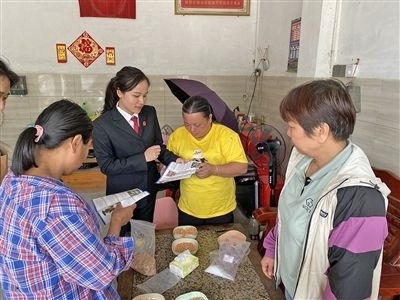  圖⑤：龍圩區(qū)法院法官到群眾家中開展法治宣傳。資料圖片