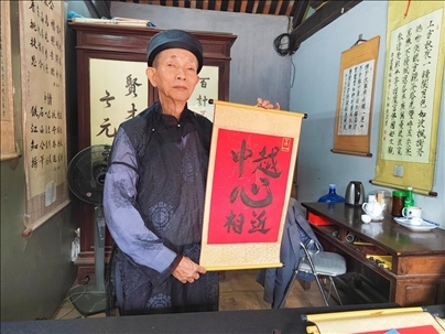 越南首都河內(nèi)文廟內(nèi)，阮明珠展示“中越心相近”書法作品。