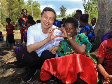 2023年12月18日，中國(guó)駐瓦努阿圖大使李名剛和前來(lái)觀看瓦努阿圖公路項(xiàng)目二期馬勒庫(kù)拉段移交儀式的當(dāng)?shù)鼐用窈嫌?。人民網(wǎng) 賀吉攝