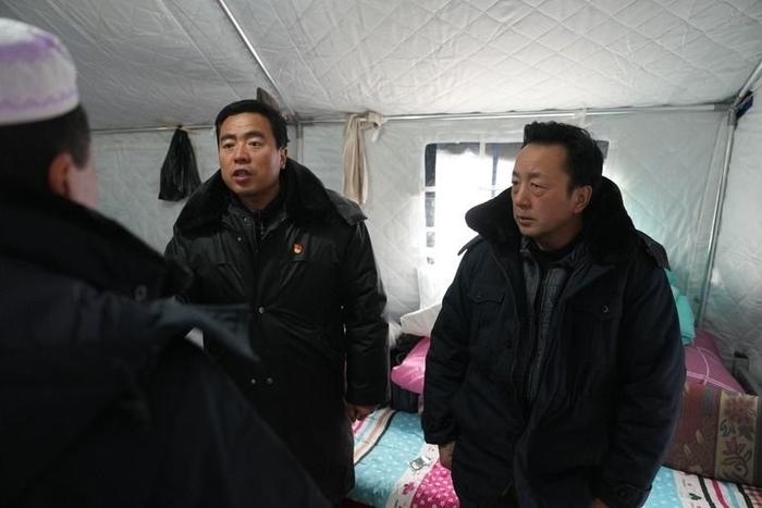 2023年12月22日，積石山縣大河家鎮(zhèn)大河村黨支部書記馬成忠（右二）在帳篷里和受災(zāi)群眾交流。新華社記者 陳斌 攝