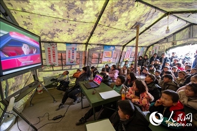 12月22日，在積石山縣大河家鎮(zhèn)大河村安置點(diǎn)，陸軍76集團(tuán)軍某旅搭建的“臨時(shí)學(xué)?！眱?nèi)，小朋友正在看動(dòng)畫片。人民網(wǎng)記者 翁奇羽攝