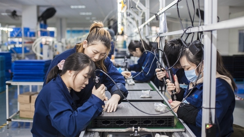 在新亞勝光電的產(chǎn)品線上，工人正進(jìn)行產(chǎn)品組建和安裝布線。受訪者供圖