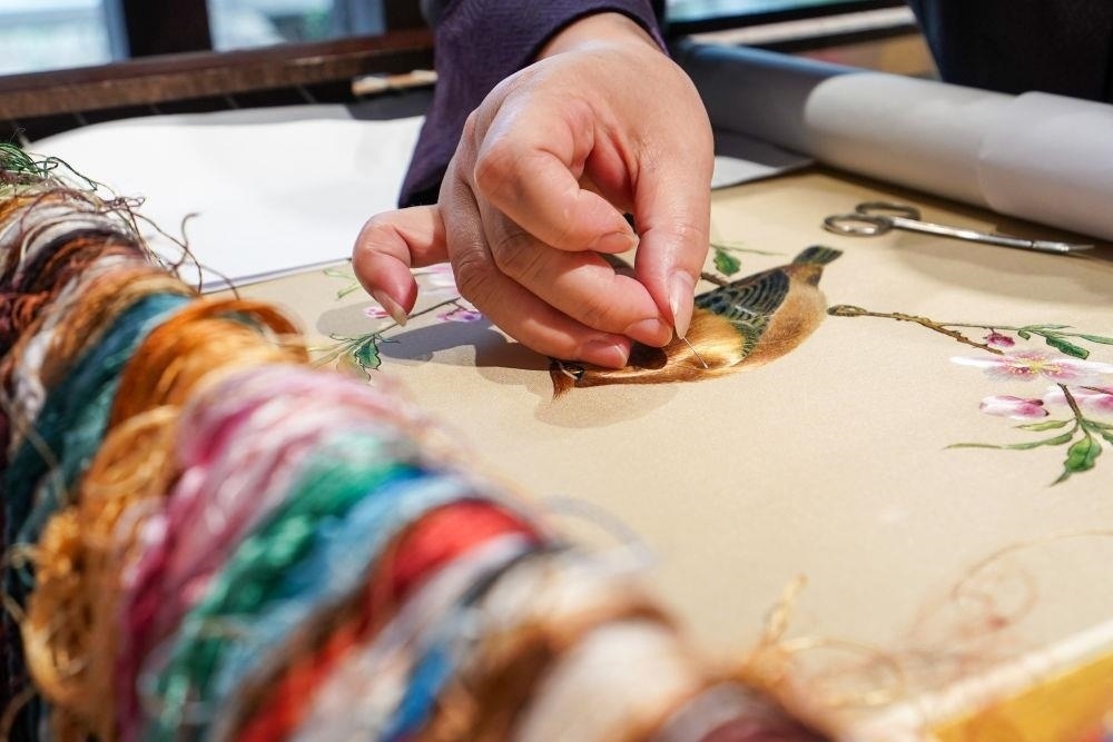 △2023年7月6日，盧建英在江蘇蘇州平江路的工作室內(nèi)刺繡。