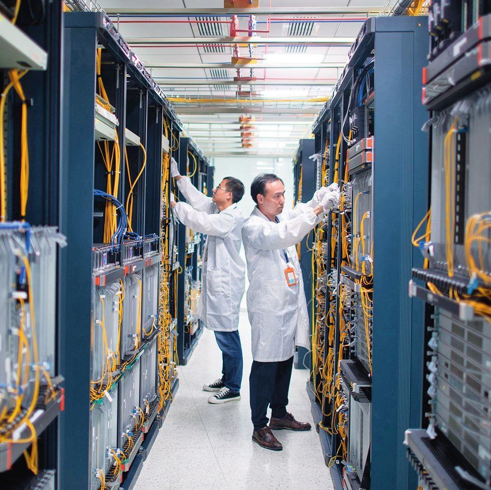 在位于武漢中國(guó)光谷的光電器件研發(fā)制造商——武漢光迅科技股份有限公司生產(chǎn)車(chē)間內(nèi)，技術(shù)人員在光模塊生產(chǎn)線作業(yè)（2023年4月11日攝）。程敏攝/本刊