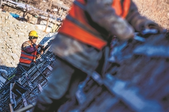 1月3日，房山區(qū)，工人正在雙泉河修筑堤壩。