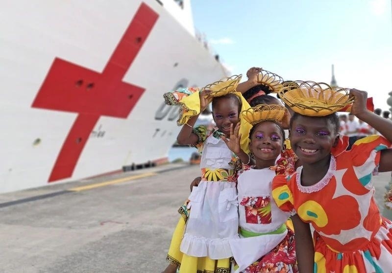 2018年10月，在安提瓜和巴布達首都圣約翰，當(dāng)?shù)匦∨笥焉泶﹤鹘y(tǒng)服裝歡迎中國海軍“和平方舟”醫(yī)院船首次到訪。