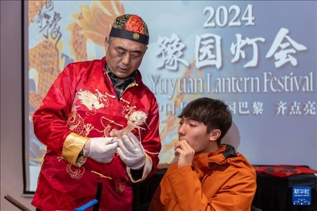 1月28日，在上海豫園舉行的民俗活動上，美國馬斯卡廷中學學生在非遺傳承人的指導下吹糖偶。 新華社記者 王翔 攝