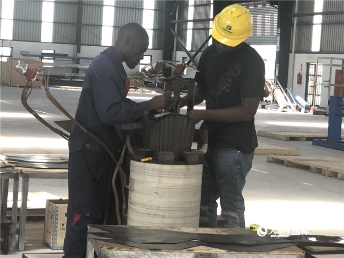 經(jīng)貿(mào)合作區(qū)廠房內(nèi)，當?shù)毓と苏诰o張作業(yè)。人民網(wǎng)記者 黃培昭攝