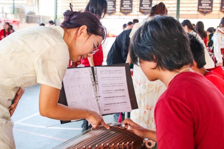 志愿者教師指導(dǎo)學(xué)生彈奏古箏?；顒?dòng)主辦方供圖