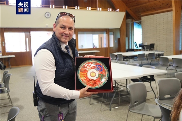 △馬斯卡廷中學(xué)高中部校長瑞安·卡斯?fàn)柎韺W(xué)校接受總臺(tái)文創(chuàng)產(chǎn)品