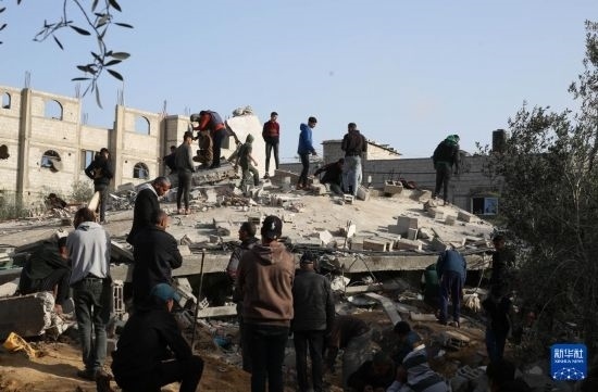  3月3日，在加沙地帶南部城市拉法，人們查看被以軍空襲破壞的建筑。新華社發(fā)（哈立德·奧馬爾攝）