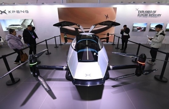 2023年12月1日，在鏈博會智能汽車鏈展區(qū)小鵬汽車展臺，參觀者觀看一臺智能飛行器。新華社記者蔡湘鑫攝