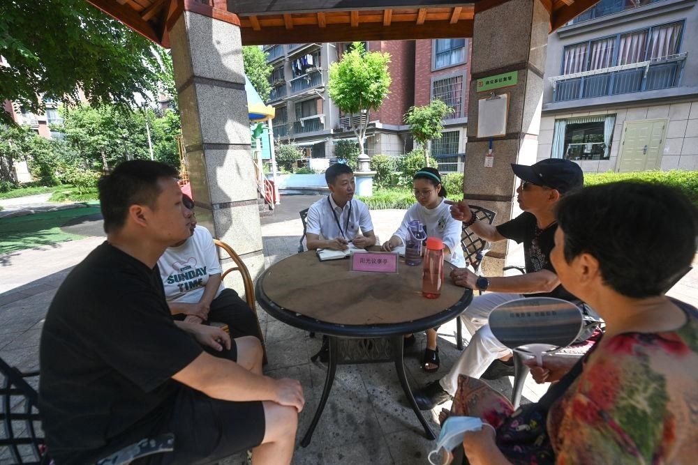△2023年7月21日，在位于浙江杭州臨安區(qū)錦南街道水岸陽光小區(qū)的陽光議事廳，街道干部在聽取居民們反映的問題及意見。