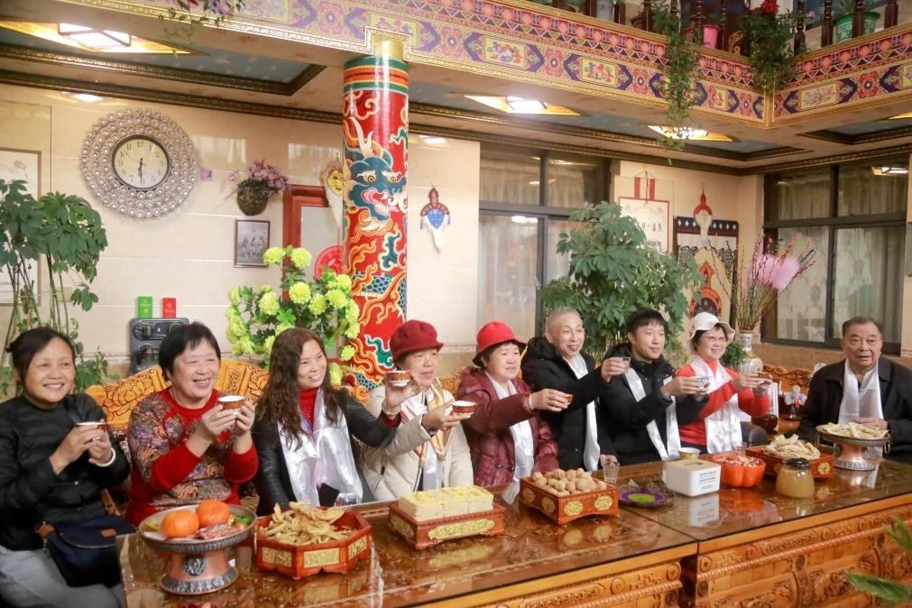 游客們?nèi)胱∶袼藓?，舉杯共飲酥油茶。新華社記者 邱星翔 攝