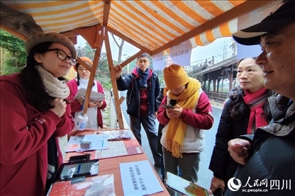 1月6日，“2024成都蒲江柑甜采摘節(jié)”上，記者見到了小萌（左一）和許多年輕人忙著做訪客接待、現(xiàn)場布置、票務核對、采摘服務等工作。人民網(wǎng)記者朱虹攝