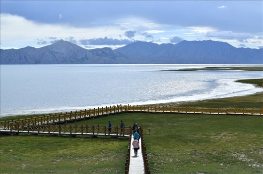 △ 游客行走在青?，敹嗫h冬格措納湖畔的木棧道上。
