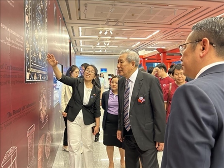 工作人員為泰國前副總理、泰中文化促進(jìn)委員會(huì)主席披尼講解展覽內(nèi)容。中國駐泰國大使館供圖