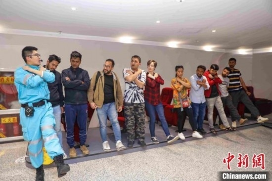 5月9日，工作人員指導(dǎo)留學(xué)生練習(xí)逃生技巧。張鷹 攝