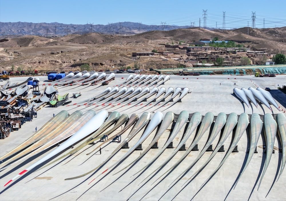 2024年5月11日拍攝的碼放在內(nèi)蒙古包頭市石拐區(qū)一家風(fēng)電設(shè)備制造企業(yè)廠區(qū)內(nèi)的葉片（無人機(jī)照片）。新華社記者 連振 攝